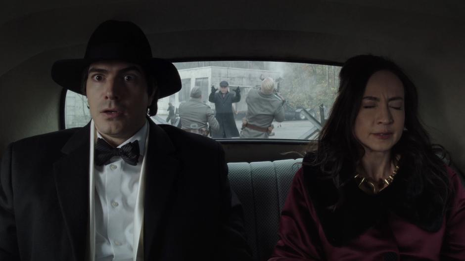 Ray and Nora wait in the car while the older Damian Darhk uses his magic to defeat the gaurds behind them.