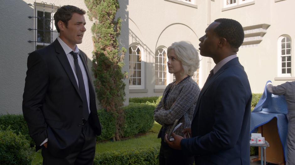 Liv and Clive talk to Mrs. Brinks' driver out front of the mansion.