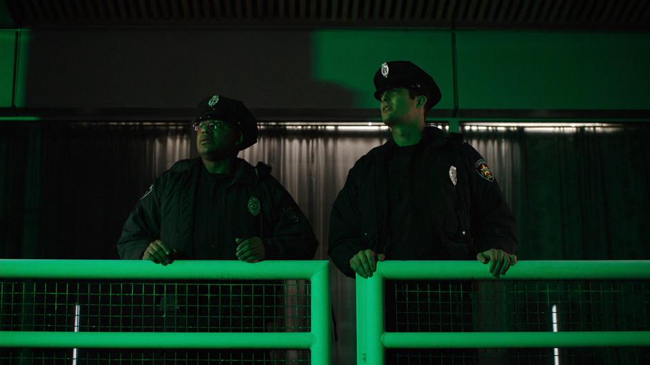 Two corrupt police officers watch the fireworks overhead.