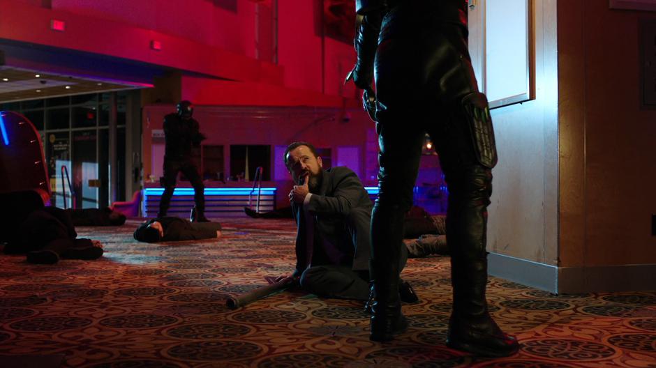 Anatoly looks up at Oliver while Diggle stands over various downed goons.
