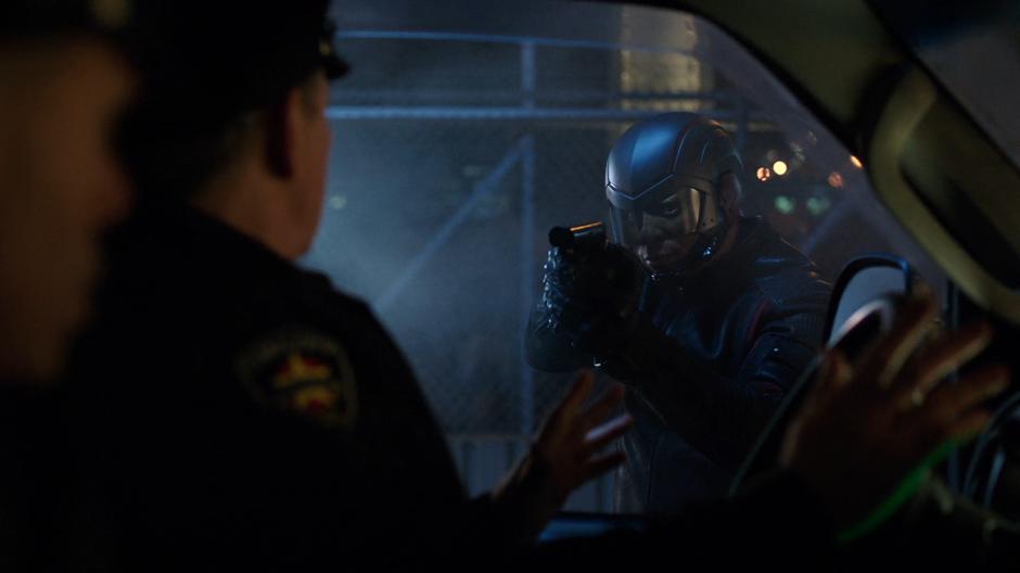 Diggle points his gun at the two transport drivers.