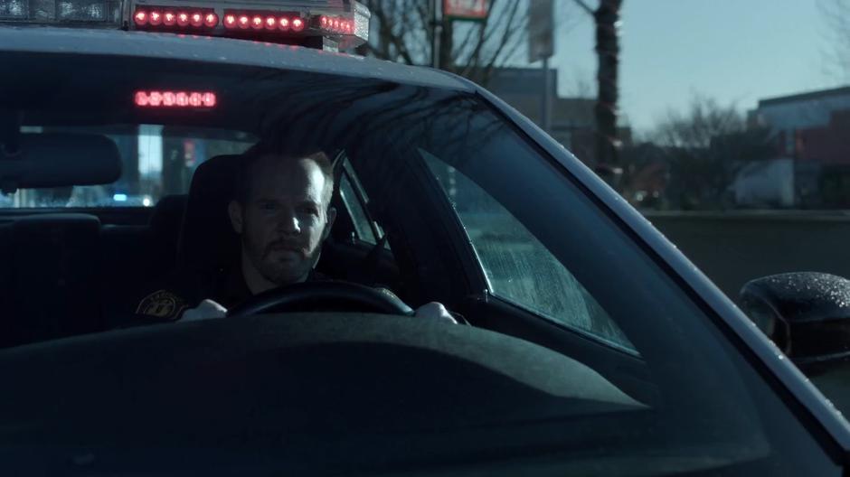 Officer Eggers drives away from the station in a squad car.