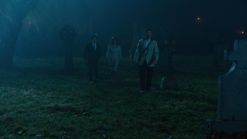 Nate, Amaya, and Elvis walk through the graveyard.