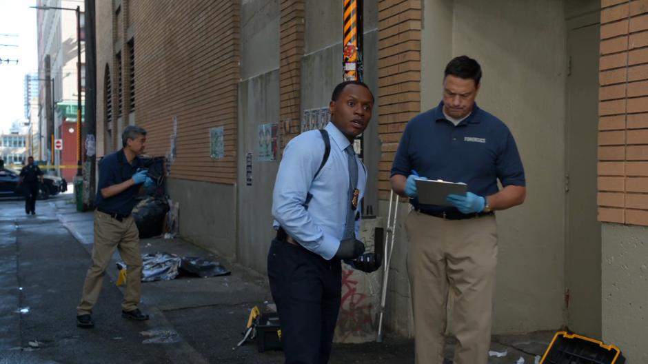 Clive looks up from his conversation with a forensics tech as Liv and Ravi approach.