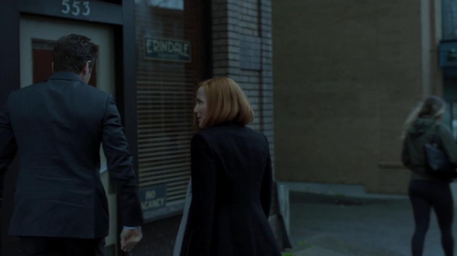 Mulder and Scully walk over to the apartment building.