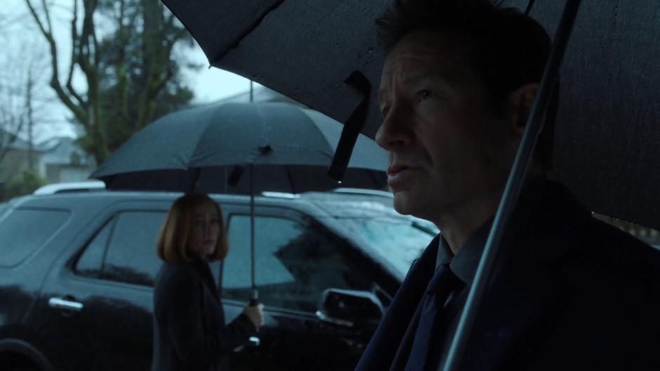 Scully looks over at Mulder as he notices the three missing metal poles.