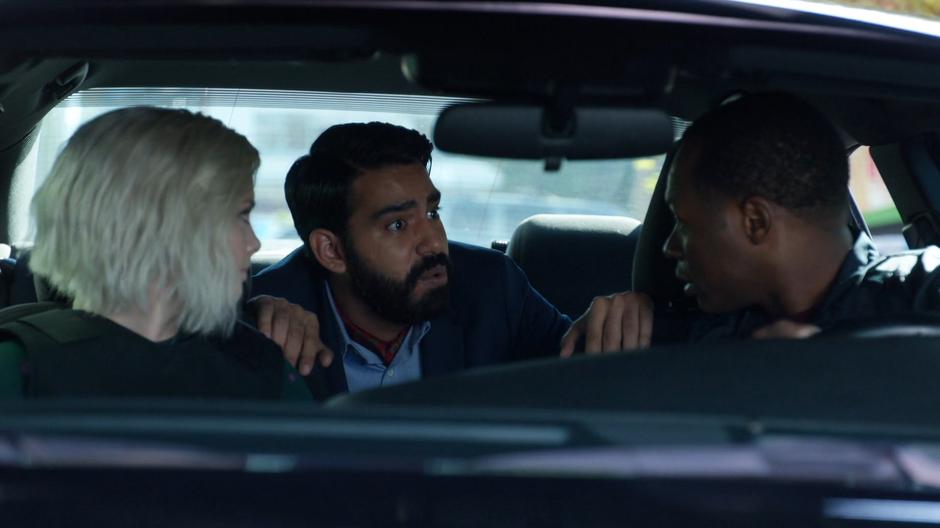 Ravi talks to Liv and Clive from the backseat of the car.