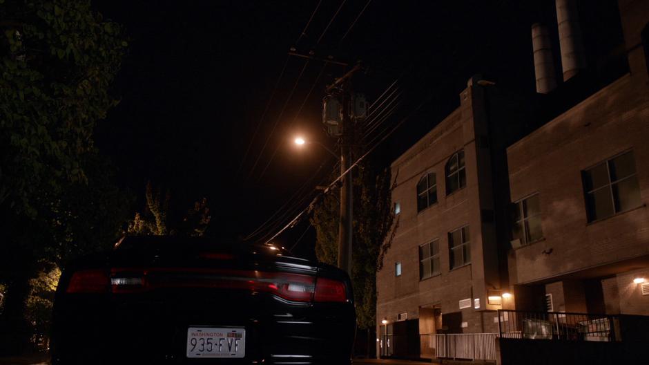 Clive's car sits on the street next to the incinerator building.