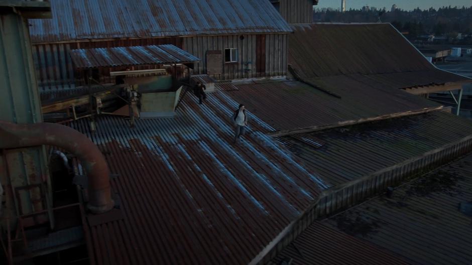 William runs down the rooftop of the building while being pursued by a soldier.