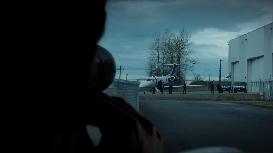 Mulder takes a photo of Mr. Y leaving his plane.