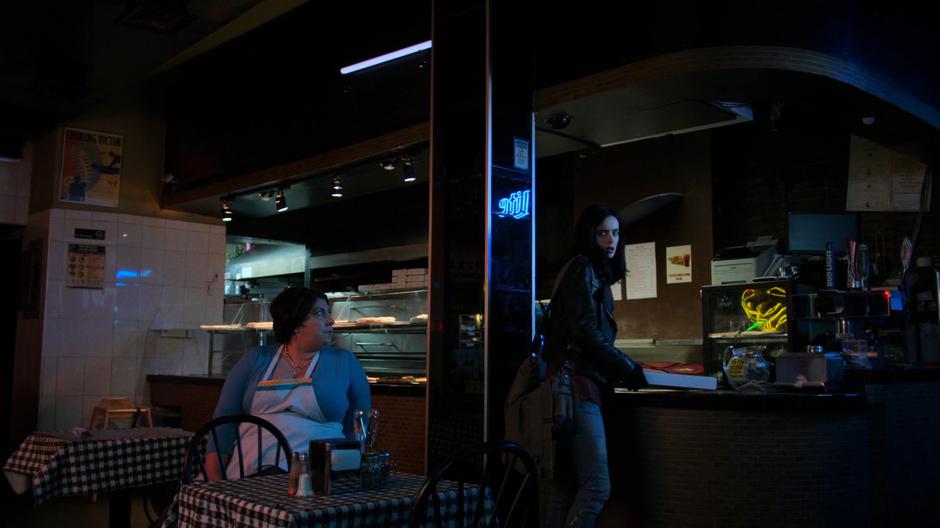The pizzeria owner watches as Jessica grabs a pizza after rejecting her offer.