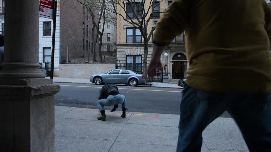 Jessica lands on the street just as the Whizzer runs out the front door.