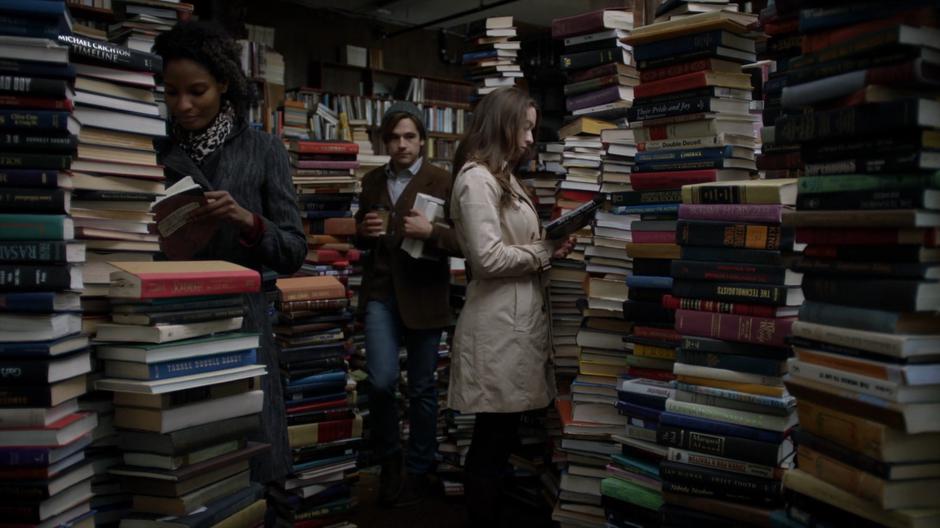 Quentin walks through the packed bookstore with a coffee and his new purchases.