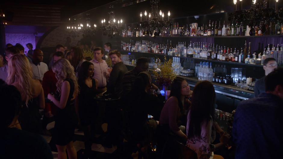 Max Roberts looks around the bar with his client after getting their drinks.