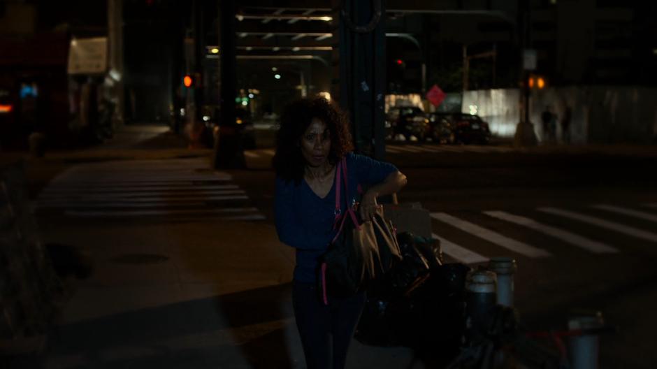 A woman walking past reaches into her handbag.