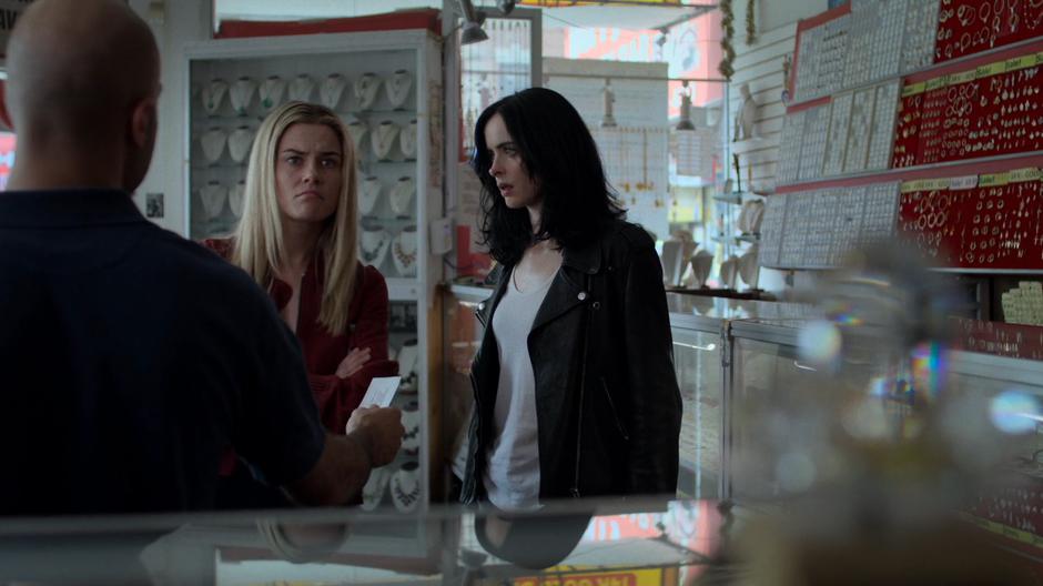 Jessica looks to Trish as she tries to intimidate the pawn shop employee.