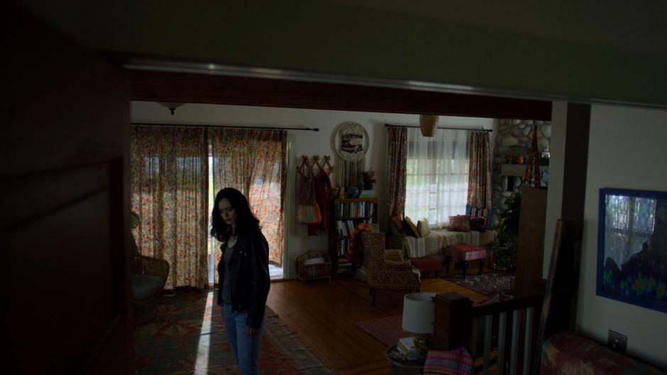 Jessica looks around inside the house's living room.