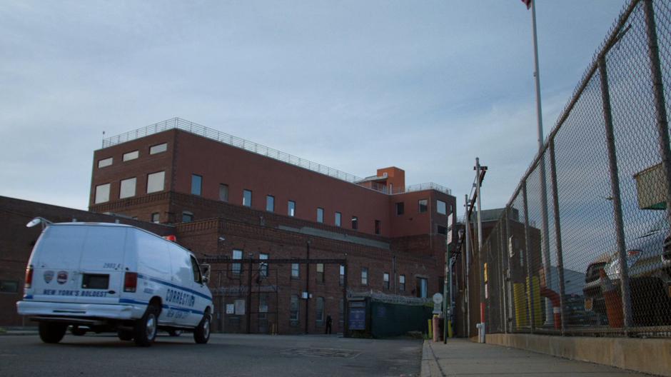 Establishing shot of the detention center as a corrections van drives towards the gate.