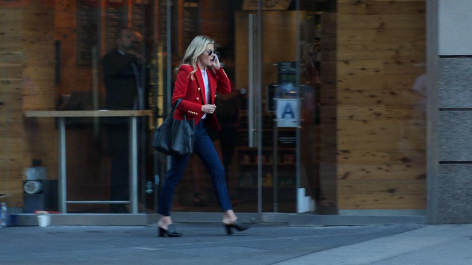 Trish talks to Jessica on the phone while striding down the street.