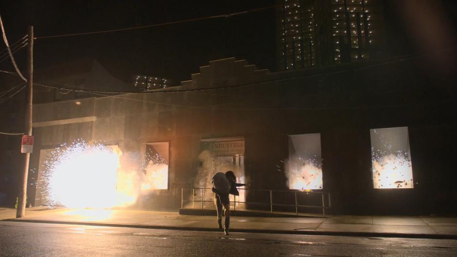 Jessica runs away from the building with Trish as it explodes behind her.