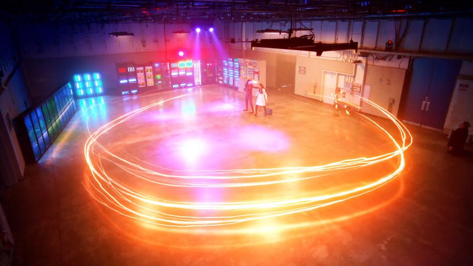 Barry circles around the space to create a lightning bolt while Cisco holds Marlize.