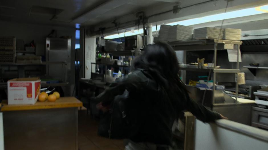 Jessica runs through the diner's kitchen.