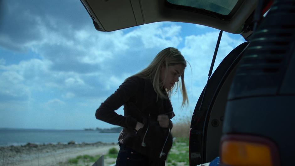 Trish hides Simpson's inhaler in her pocket while searching the trunk of his SUV.