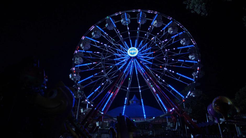 The ferris wheel lights up after Alisa turns it on.
