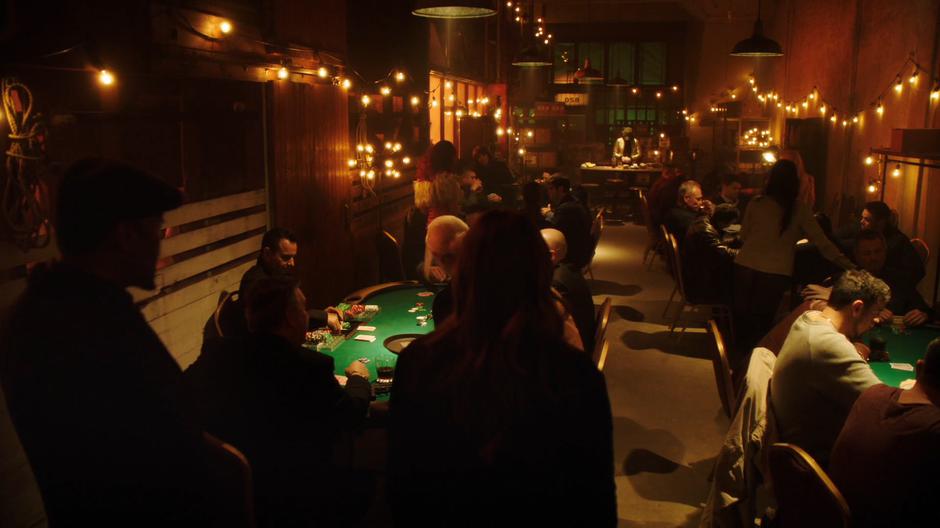 Joe and Caitlin enter the back room to find an illegal poker room.