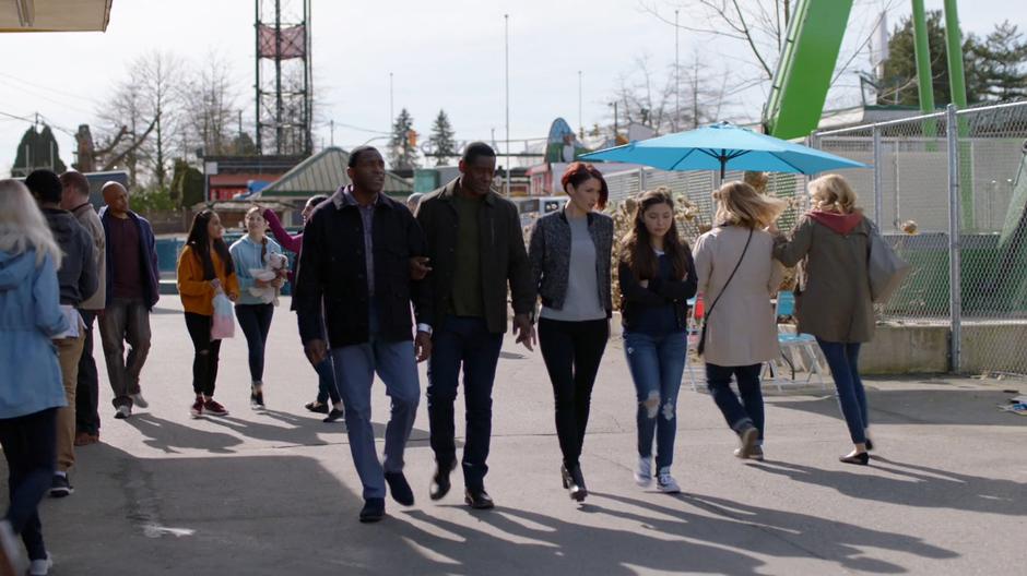 M'yrnn, J'onn, Alex, and Ruby walk through the carnival to the arcade.