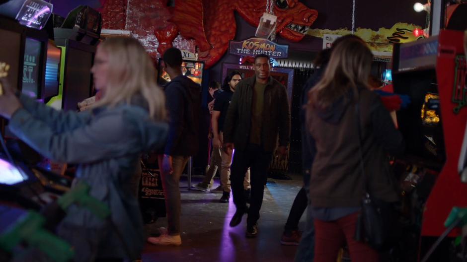 J'onn walks back to the front of the arcade after paying off the manager for damages.