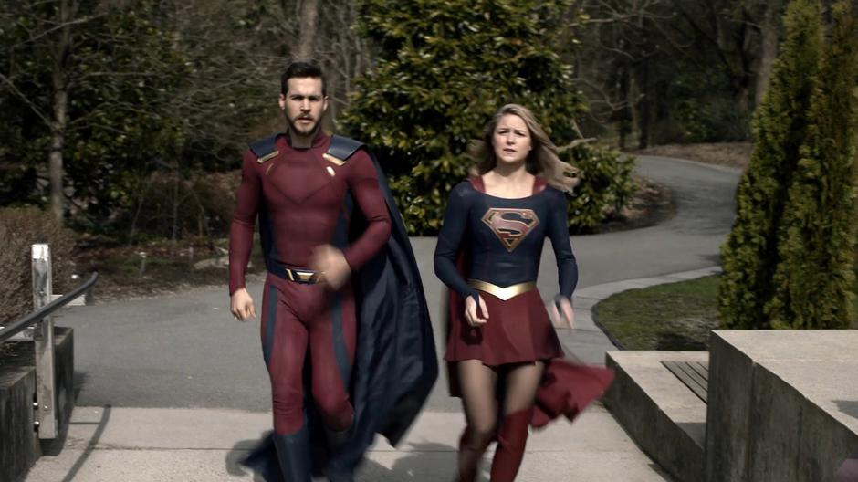 Kara and some dude jog into the edge of town.
