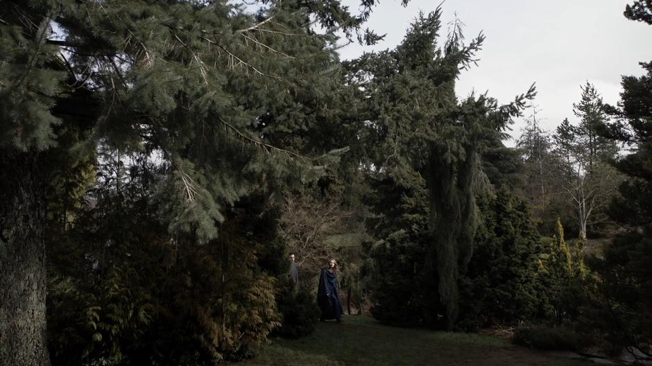 Kara walks through the woods to where the stone is held.