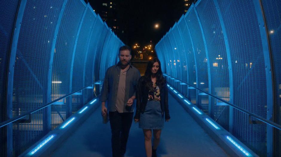 Shaun and Nina walk across the pedestrian bridge.