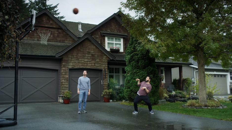 Jack watches the basketball fly towards the hoop while Dave strikes a ridiculous pose.