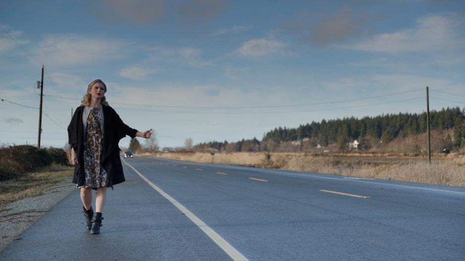 Liv stands on the side of the road trying to hitchhike back to Seattle.