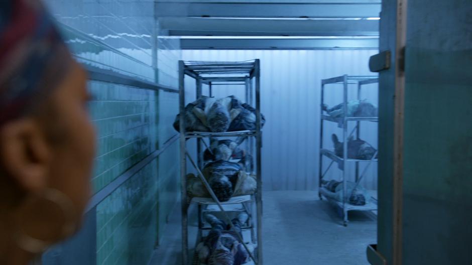 Mama Leone looks into the freezer where the frozen zombies are being stored.