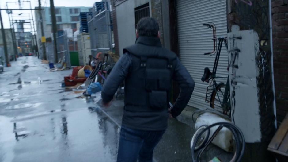 The reporter runs back down the alley to safety.