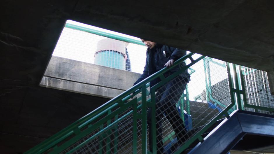 A police officer runs down the stairs after the criminal.