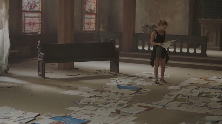 Tandy looks around at all of the evidence she has assembled on the floor and decides where to put her new printouts.