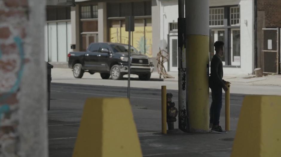 Tyrone hides behind a pillar while following the dealer.