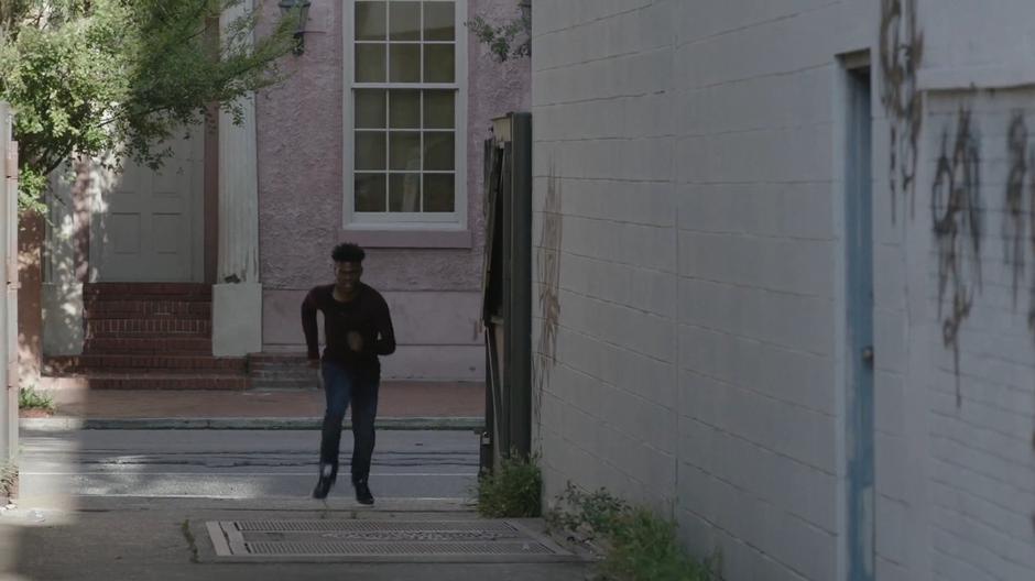 Tyrone rounds the corner and sprints down the alley.