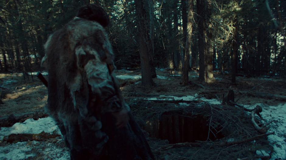 The Revenant walks up to the his pit trap where he believes Wynonna fell.