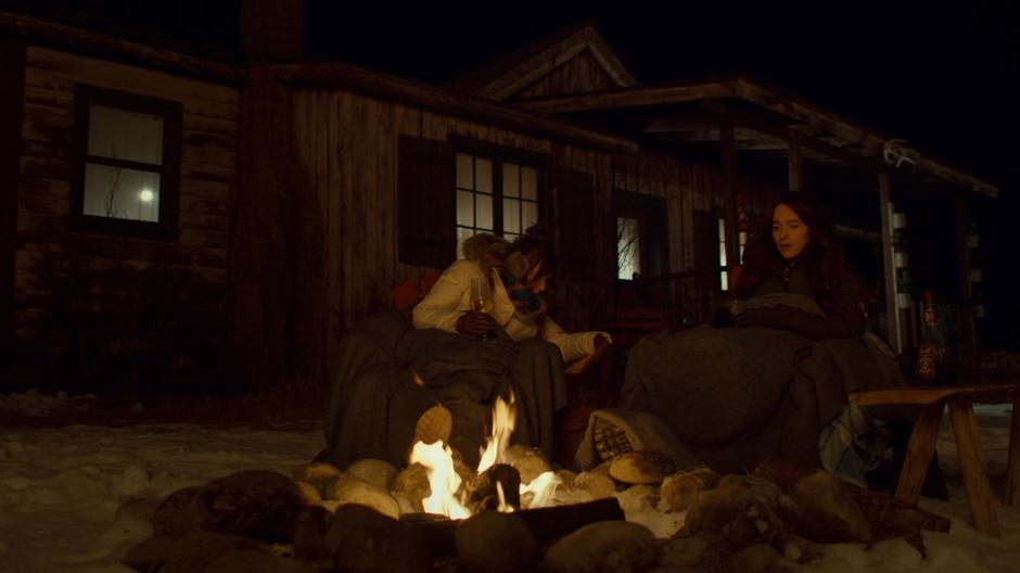 Waverly and Wynonna sit beside the fire drinking at night.