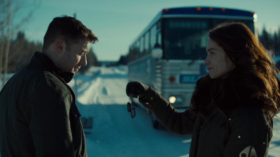 Wynonna hands Dolls' dog tags to Quinn as the bus stops.