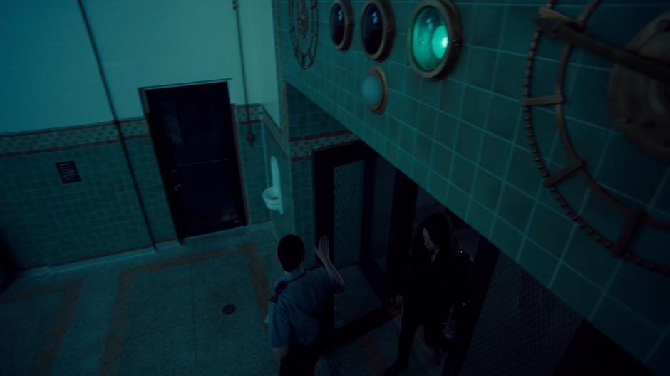 A guard holds the door open to let Wynonna into the visitation room.