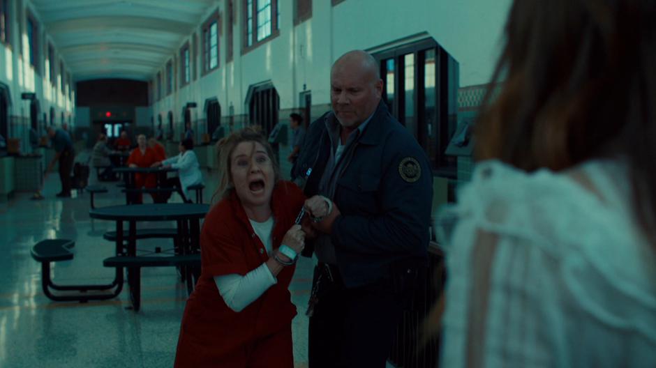 Michelle Gibson yells at Waverly while being held back by the guard.