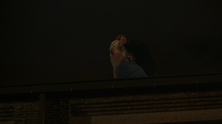 Tyrone appears on the rooftop with Connors who looks over the edge in fear.