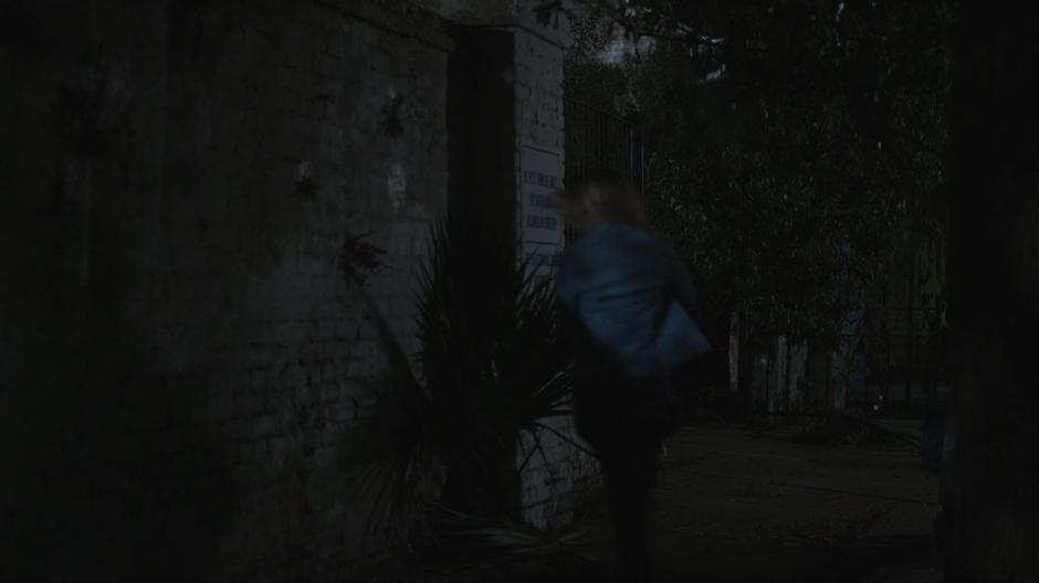 Tandy runs through the entrance into the cemetery.