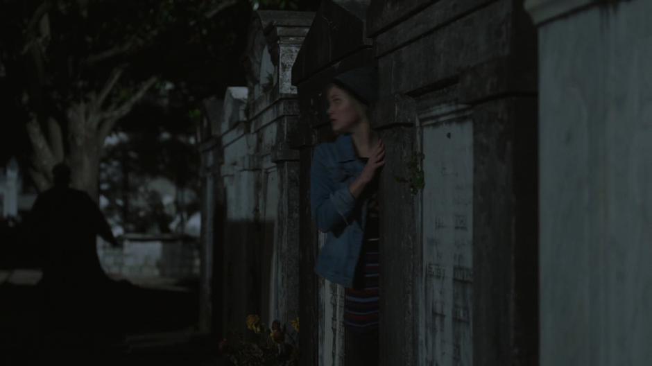 Tandy peaks out from behind a grave as Tyrone searches for her.